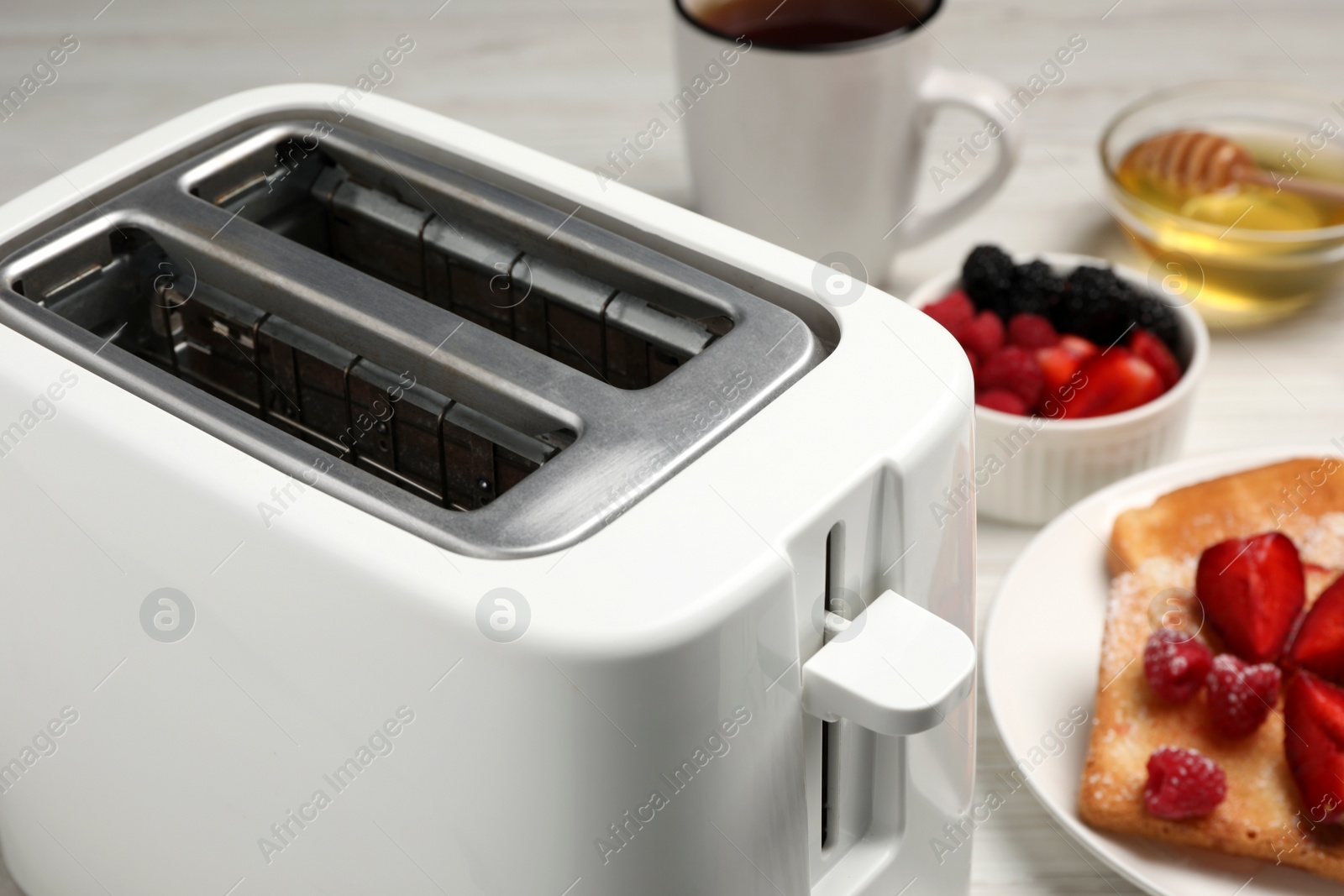 Photo of Modern toaster and products on table, closeup