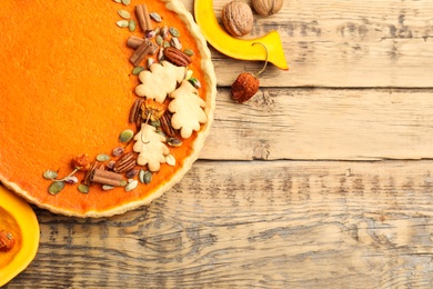 Photo of Delicious homemade pumpkin pie on wooden table, flat lay. Space for text