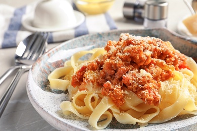 Plate with delicious pasta bolognese on table, closeup