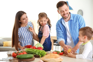 Photo of Happy family with children having breakfast in kitchen