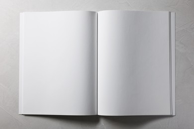 Photo of Open notebook with blank pages on grey textured background, top view. Mockup for design