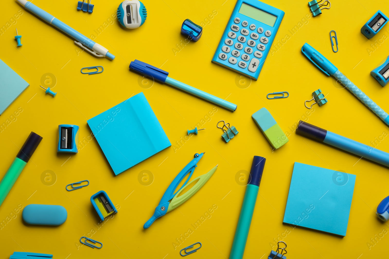 Photo of School stationery on yellow background, flat lay. Back to school