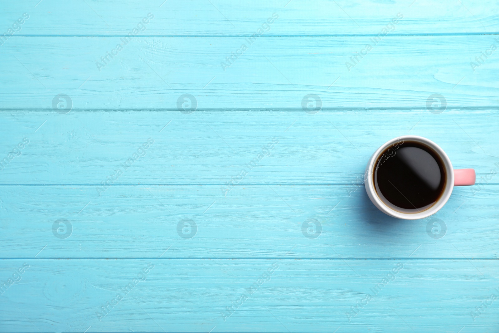 Photo of Ceramic cup with hot aromatic coffee on wooden background, top view