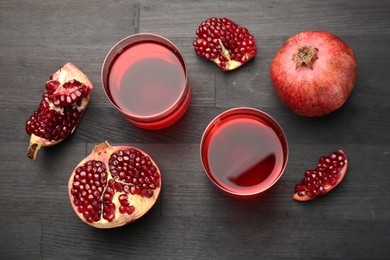 Photo of Tasty pomegranate juice in glasses and fresh fruits on black wooden table, flat lay