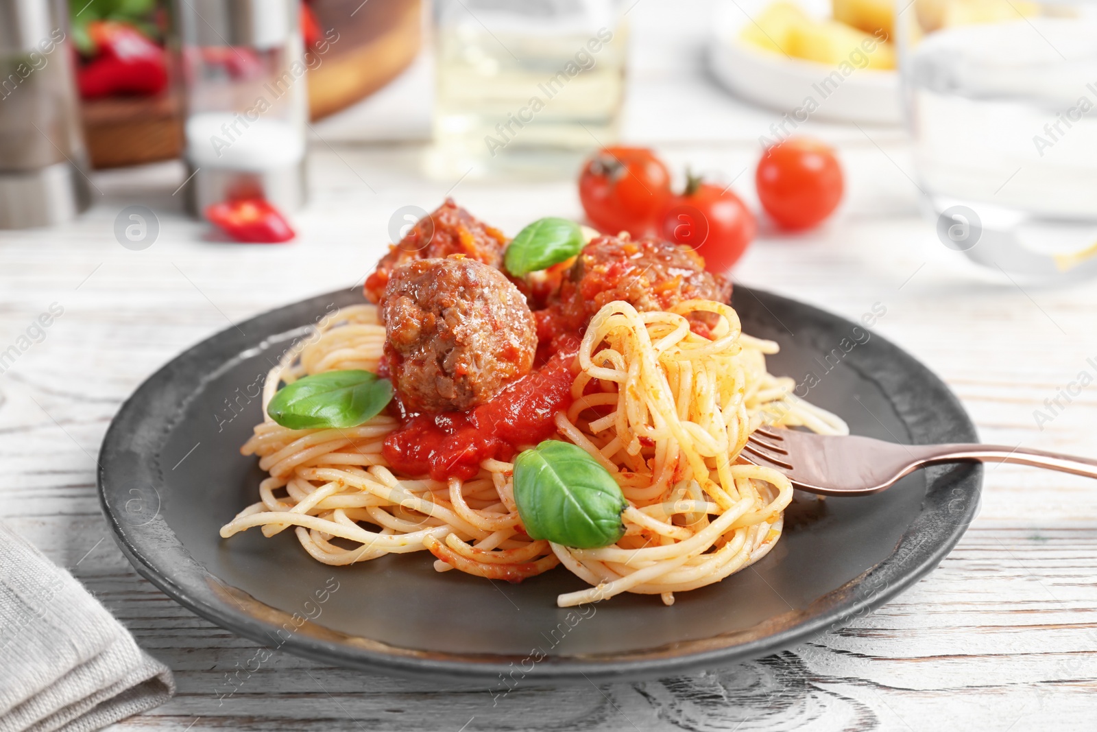 Photo of Delicious pasta with meatballs and tomato sauce on wooden table