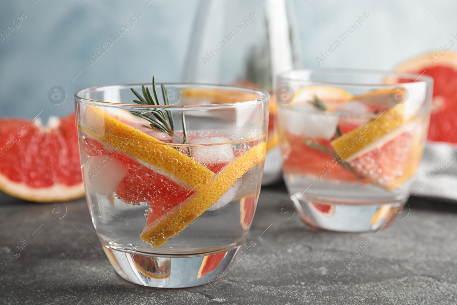 Photo of Glasses of infused water with grapefruit slices on table. Space for text