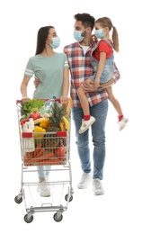 Family in medical masks with shopping cart full of groceries on white background