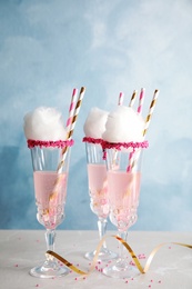 Photo of Cocktail with cotton candy in glasses on table
