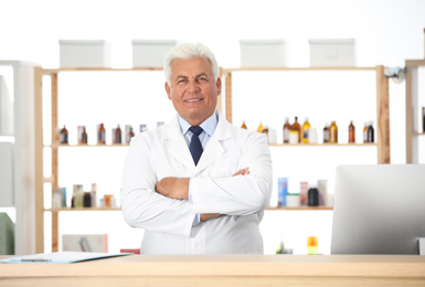 Portrait of happy senior pharmacist in drugstore