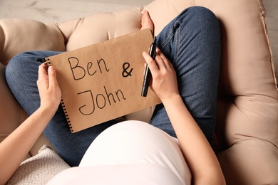 Photo of Pregnant woman choosing name for baby, closeup