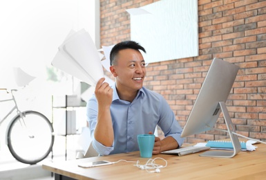 Photo of Happy young businessman enjoying peaceful moment at workplace