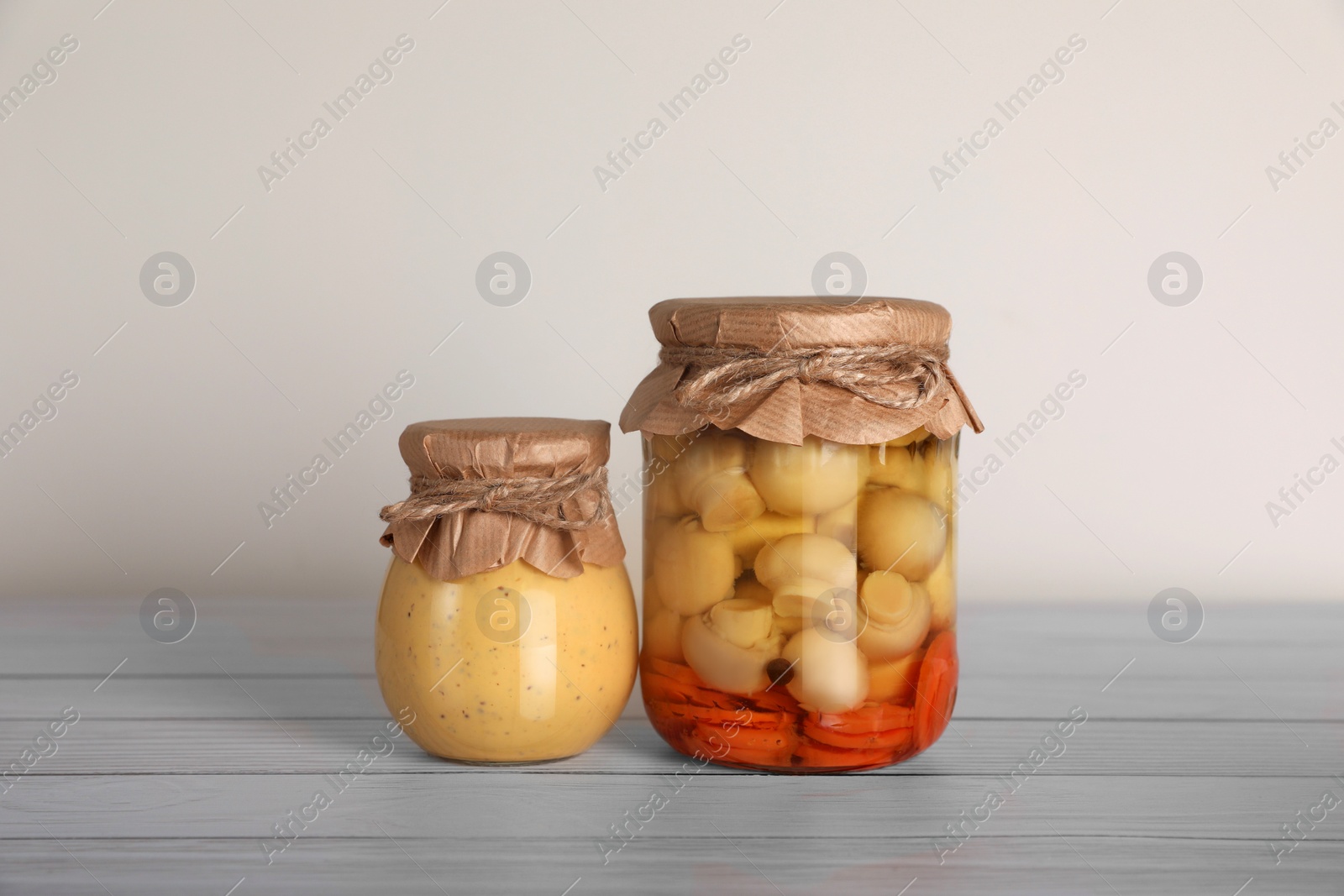 Photo of Jars with preserved ingredients on wooden table