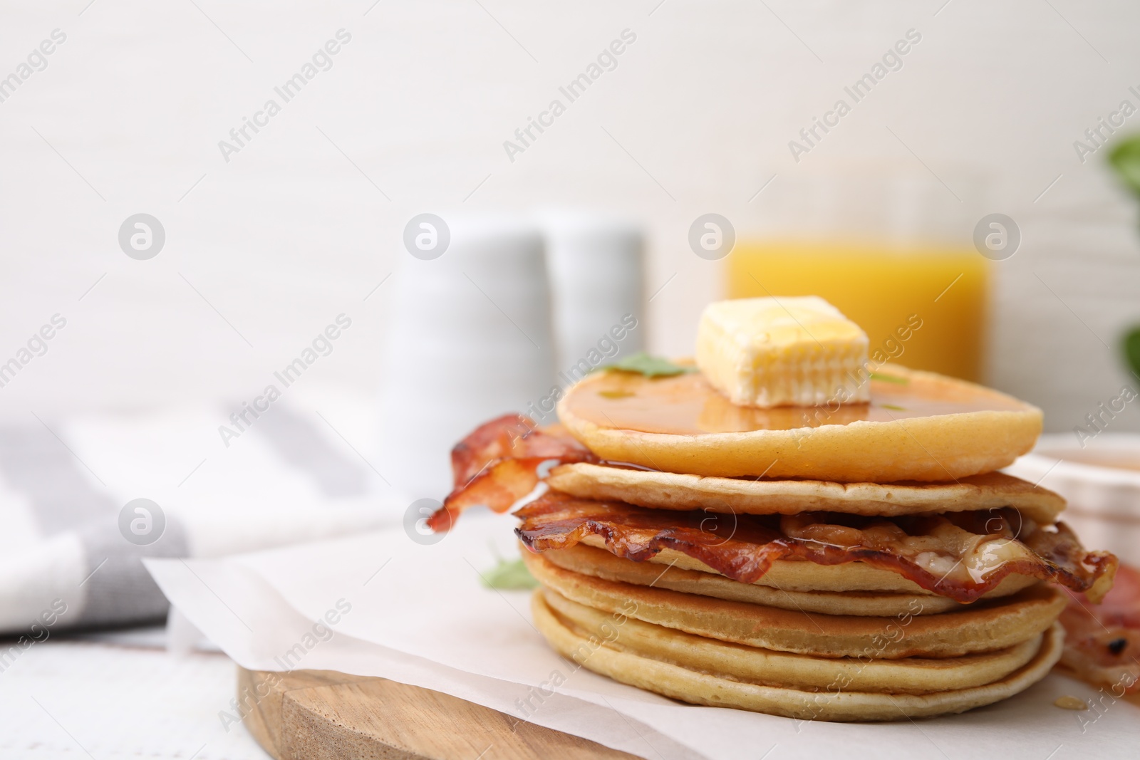 Photo of Delicious pancakes with bacon, butter and honey on table, closeup. Space for text