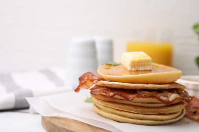 Delicious pancakes with bacon, butter and honey on table, closeup. Space for text