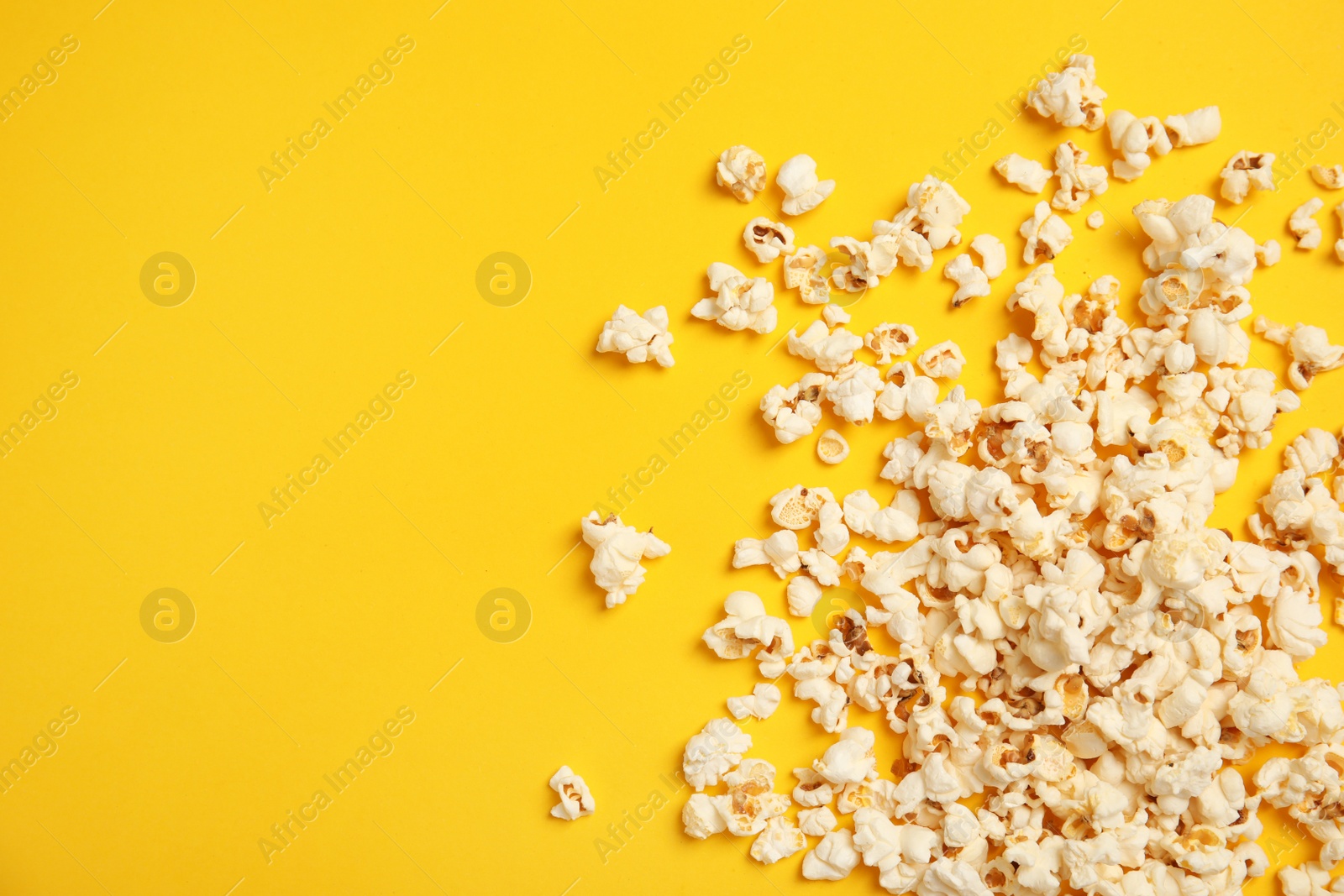 Photo of Tasty fresh popcorn on color background, top view