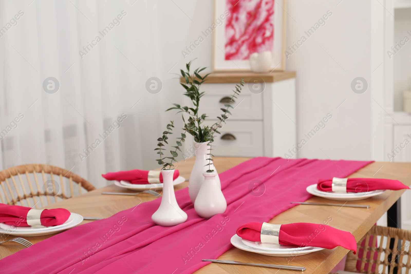 Photo of Beautiful table setting and vases with green branches in dining room