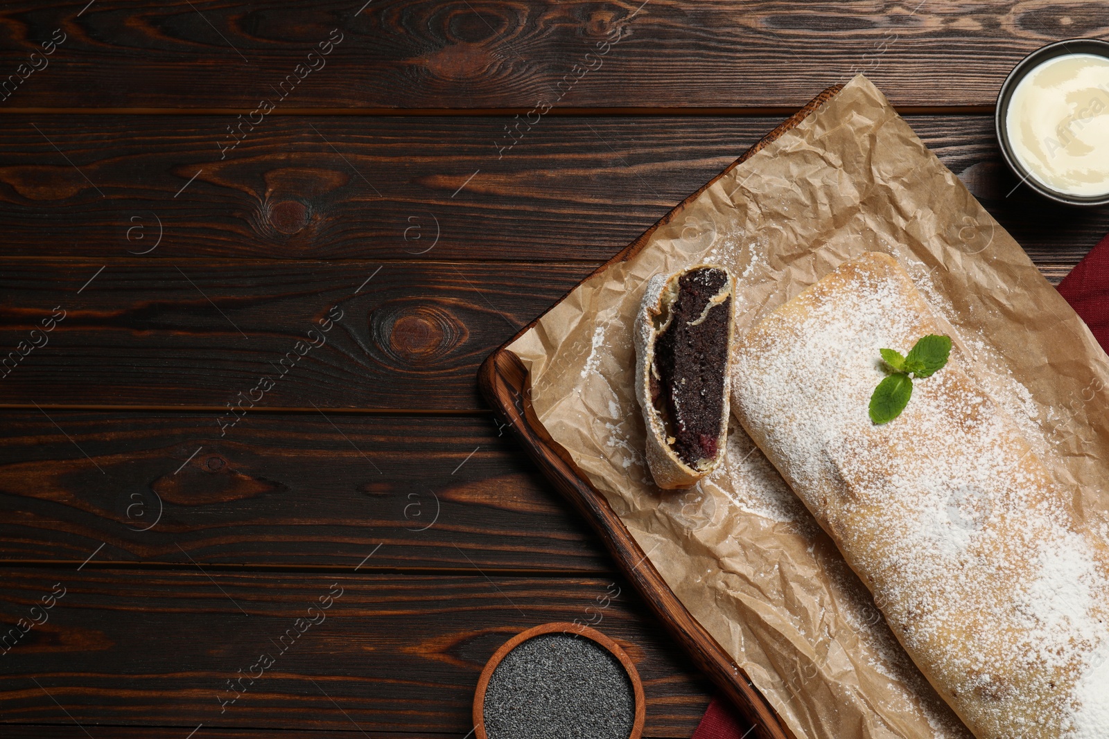 Photo of Delicious strudel with tasty filling served on wooden table, flat lay. Space for text