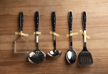 Set of clean kitchen utensils on wooden background, flat lay