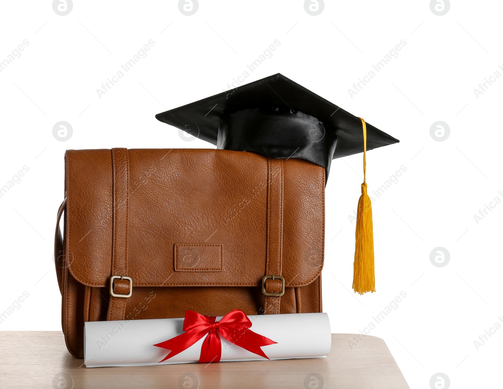 Photo of Briefcase with graduation hat and diploma on table against white background