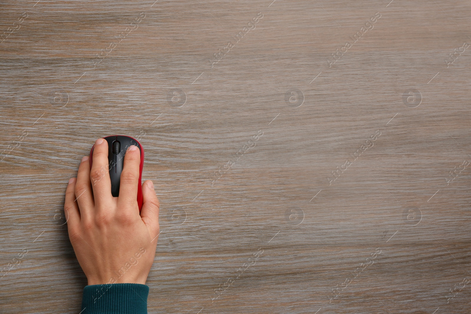 Photo of Man using computer mouse on wooden table, top view. Space for text