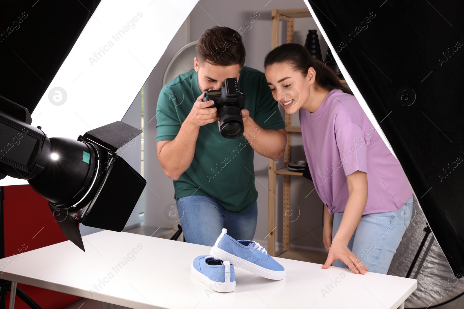 Photo of Professional photographers shooting stylish shoes in studio