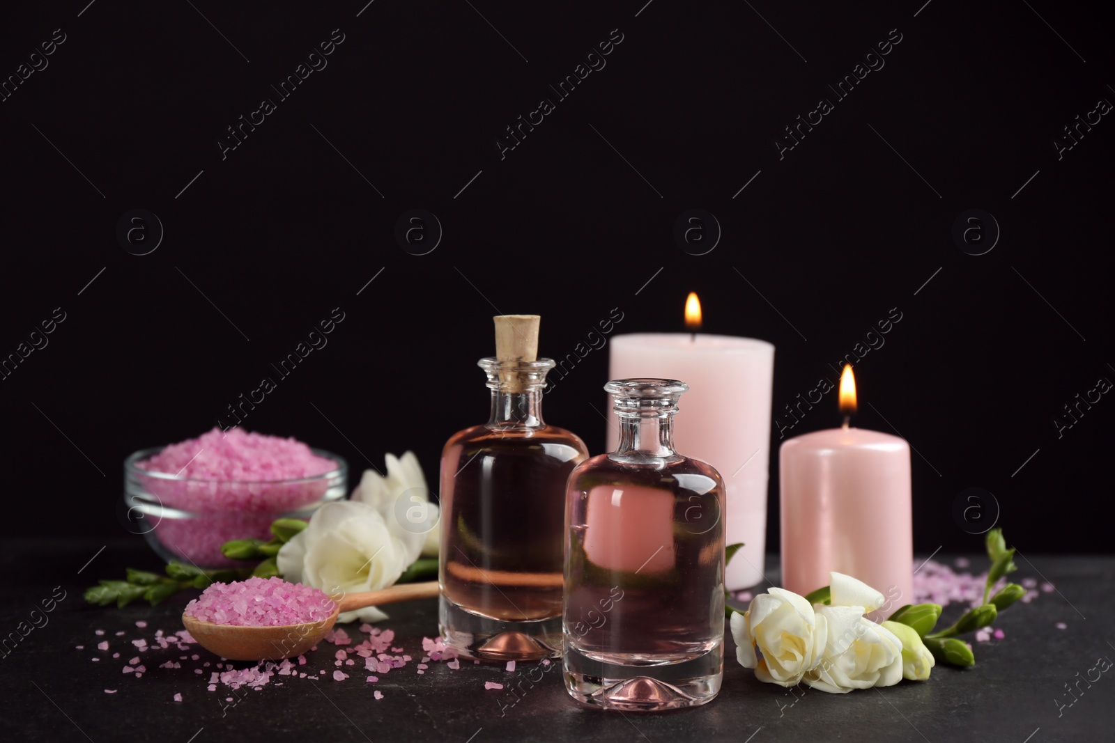 Photo of Beautiful spa composition with essential oil and candles on black table