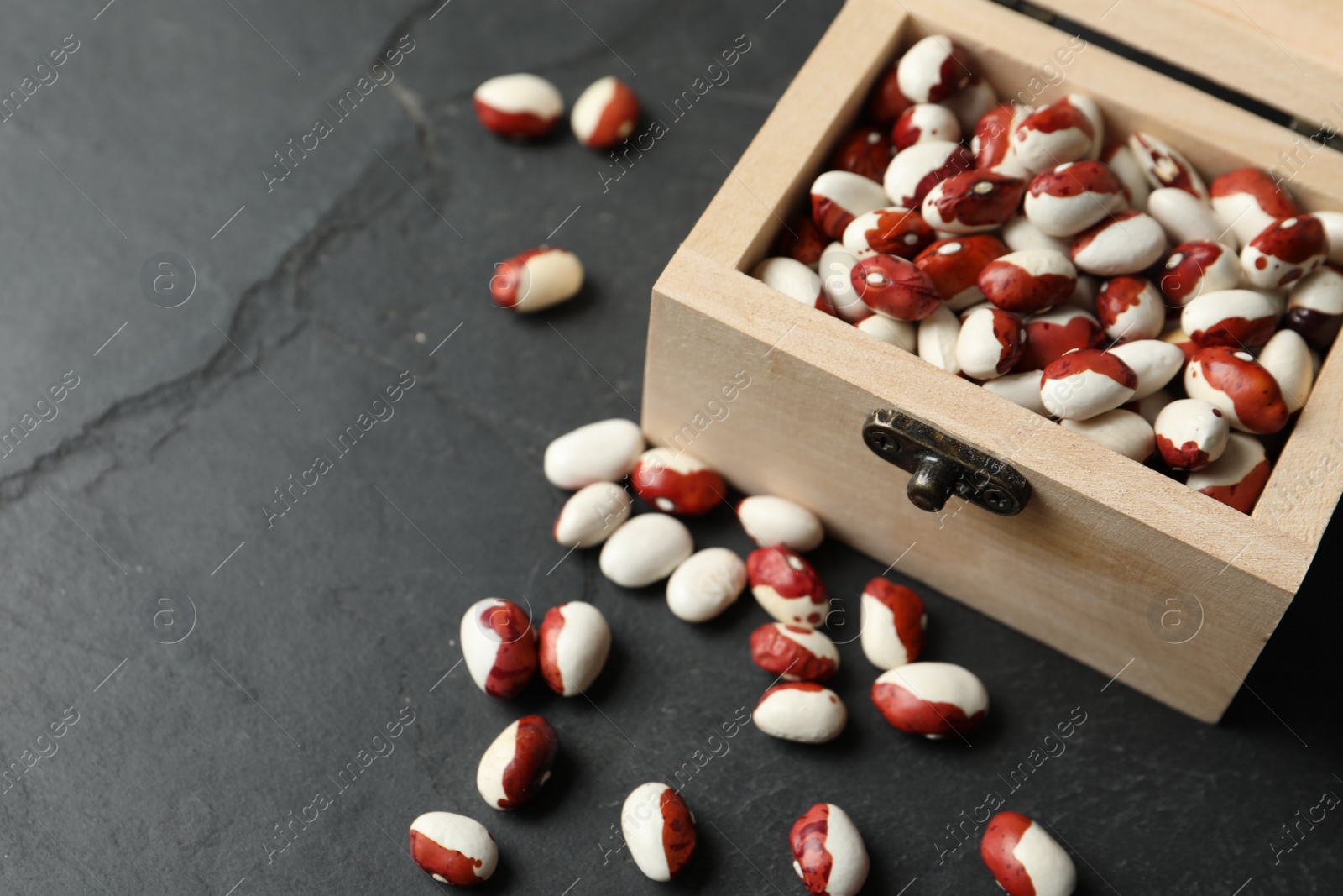 Photo of Wooden box with raw beans on grey background, closeup. Vegetable seeds