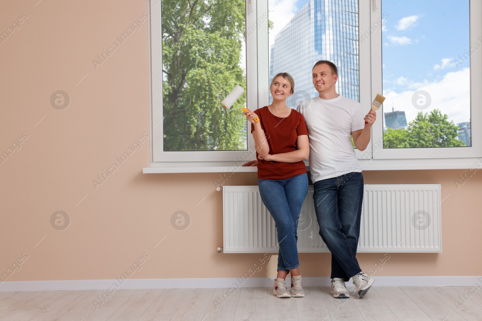 Photo of Happy couple discussing interior details in apartment during repair