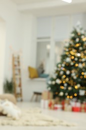 Photo of Blurred view of decorated Christmas tree and gift boxes in living room. Interior design