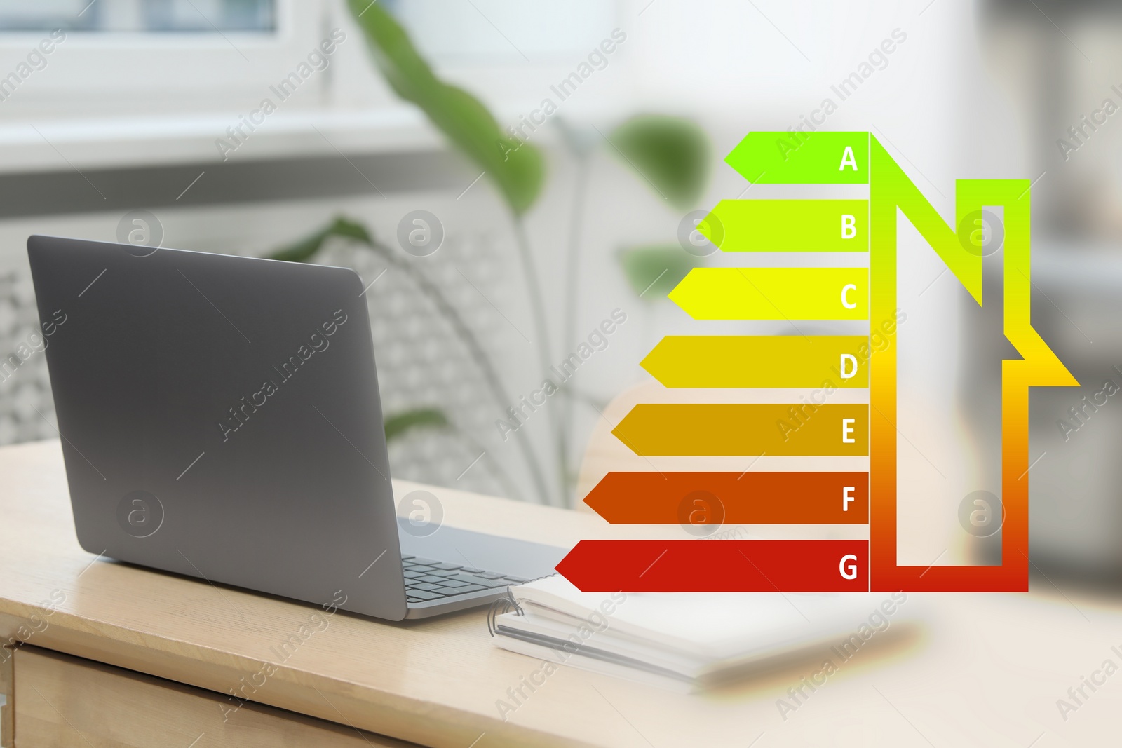 Image of Energy efficiency rating and workplace. Wooden table with laptop indoors