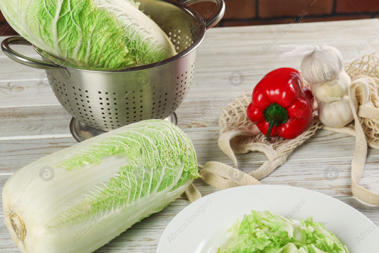 Photo of Fresh Chinese cabbage, bell pepper and garlic on wooden table