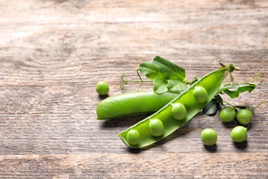 Photo of Delicious fresh green peas on wooden table