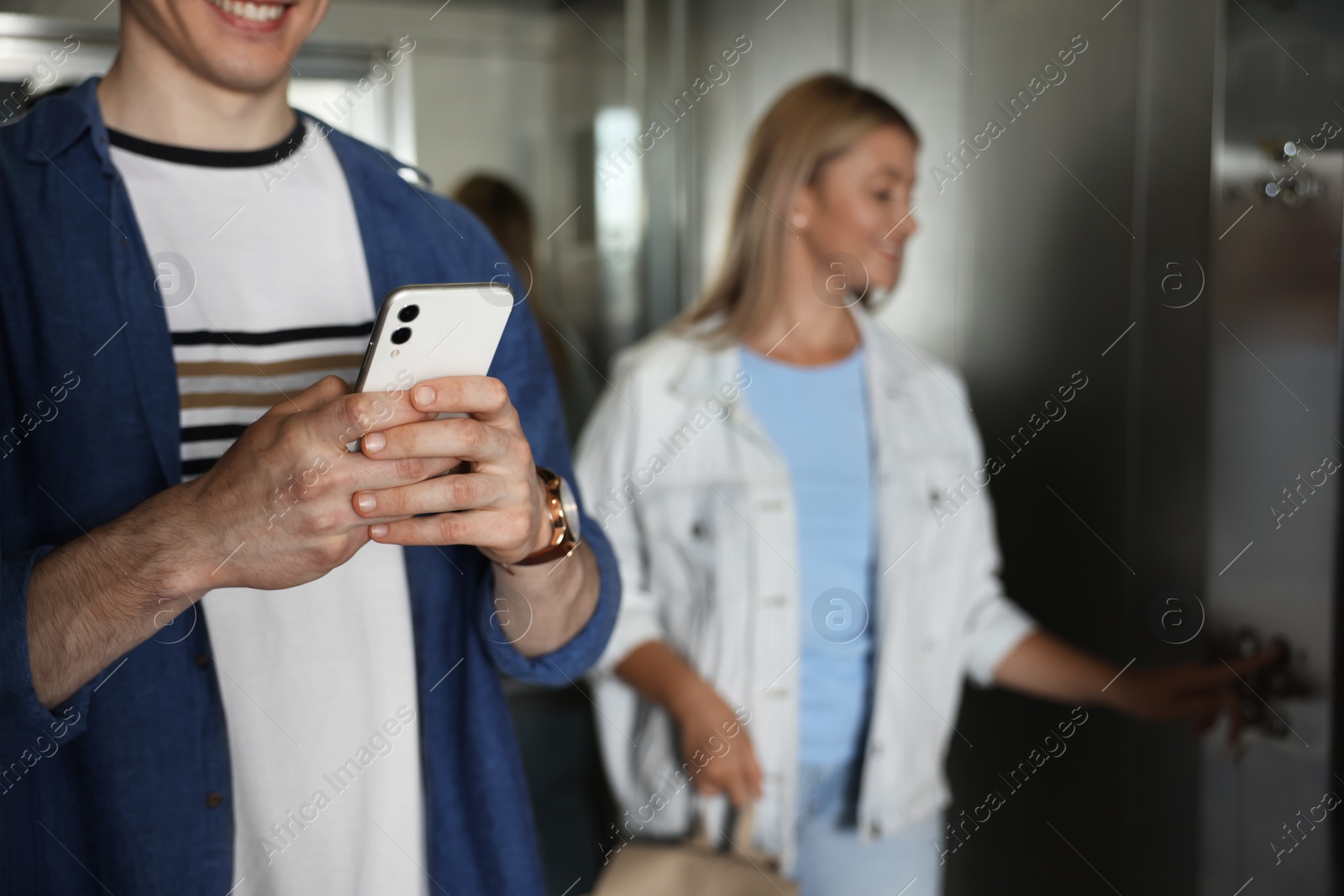 Photo of Young people taking ride in elevator together