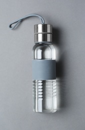 Sport bottle with water on color background