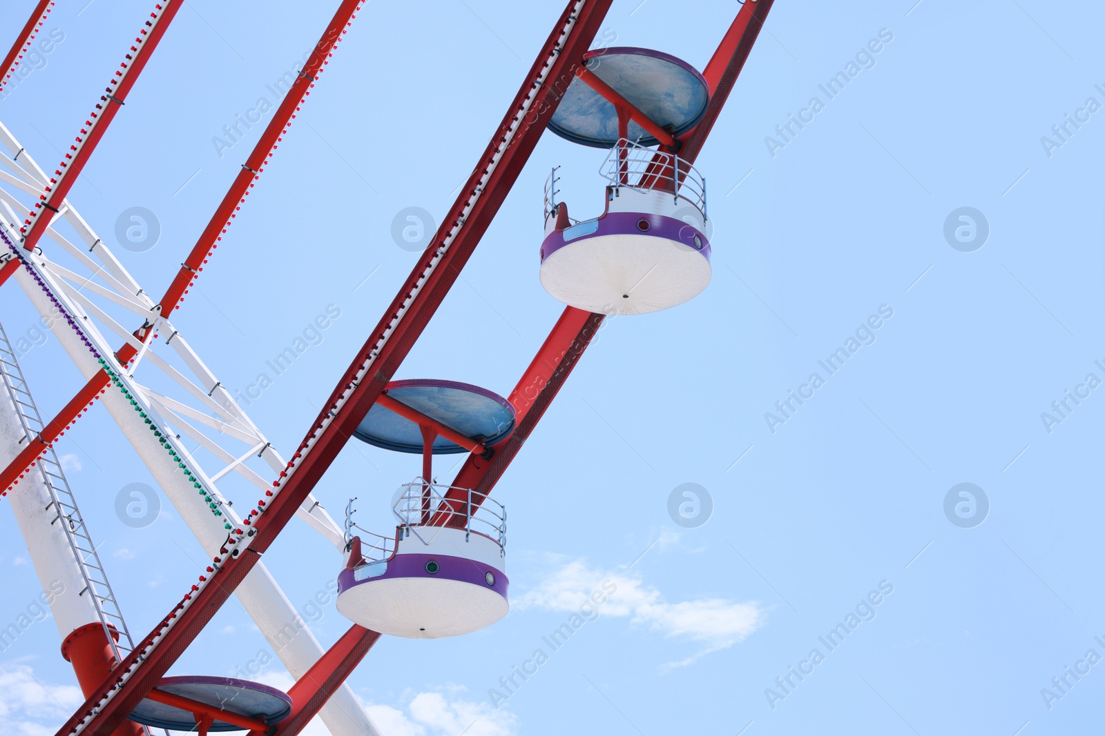 Photo of Beautiful large Ferris wheel and palm tree against blue sky, low angle view