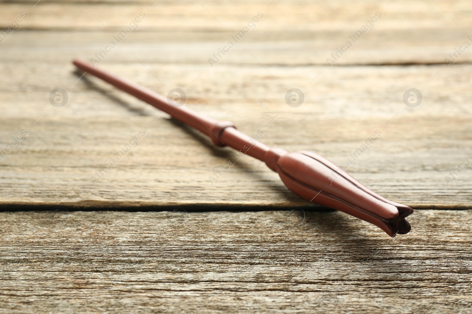 Photo of One old magic wand on wooden table, closeup