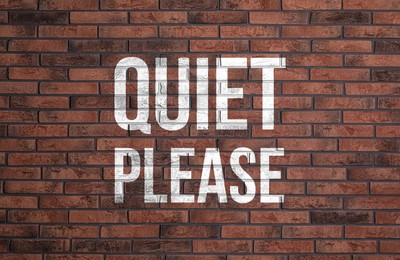 Image of Phrase Quiet Please on red brick wall