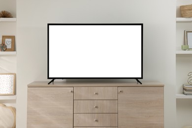 Image of Modern TV set on wooden cabinet in room