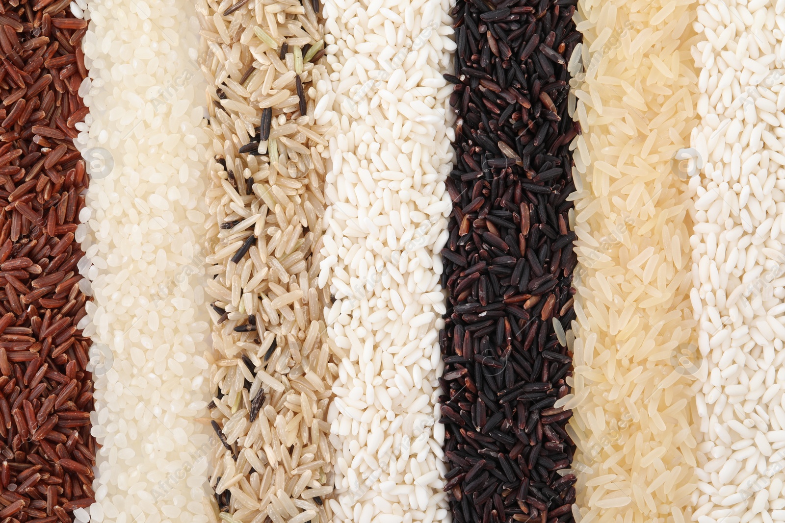 Photo of Different sorts of rice as background, top view