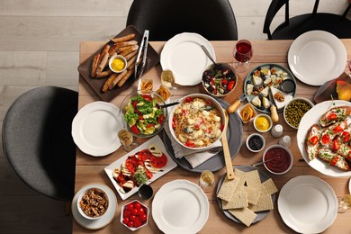 Photo of Brunch table setting with different delicious food and chairs indoors, top view