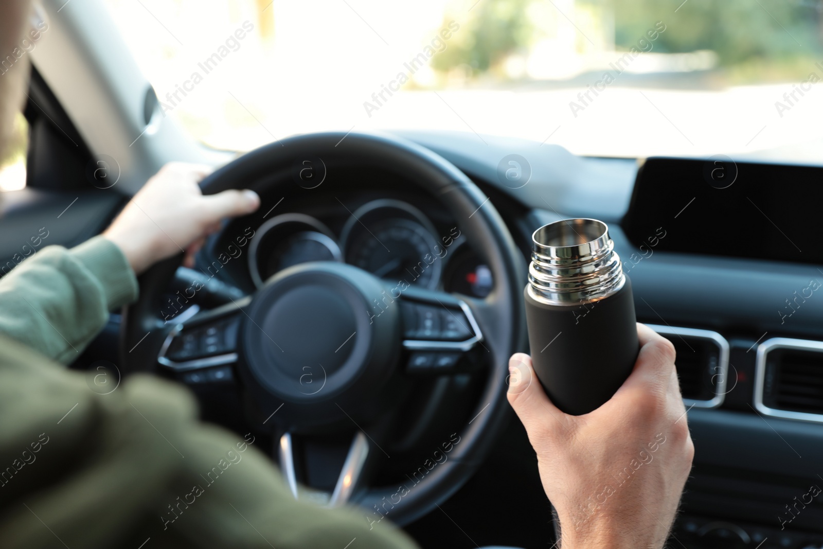 Photo of Man with thermos driving car, closeup view