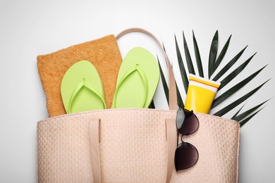 Flat lay composition with sunscreen and beach accessories on white background