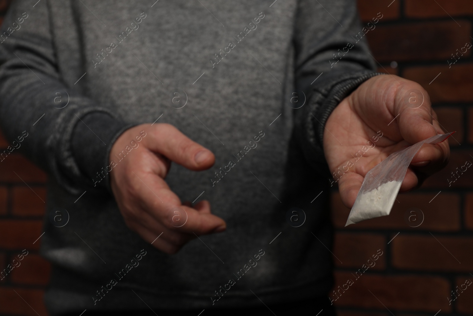 Photo of Drug addiction. Man with plastic bag of cocaine on blurred background, selective focus