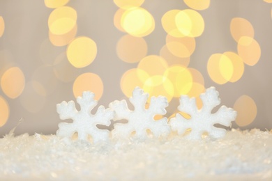 Photo of Beautiful decorative snowflakes against blurred festive lights