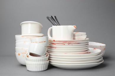Set of dirty dishes on grey background