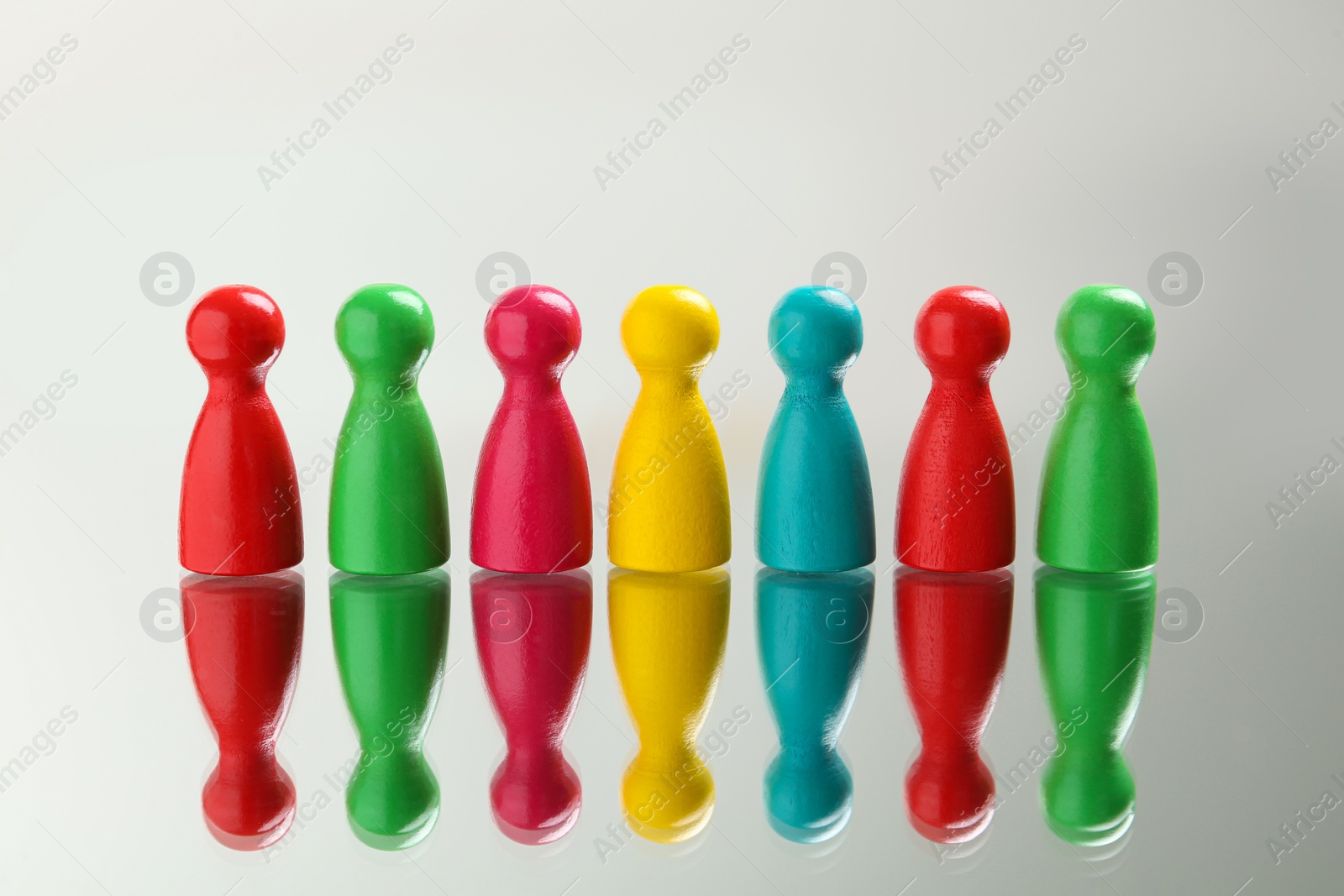 Photo of Colorful pawns on white background. Social inclusion concept