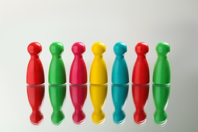 Photo of Colorful pawns on white background. Social inclusion concept