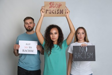Photo of Group of people holding signs on grey background. Racism concept