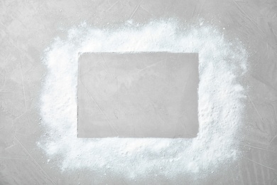 Frame made of snow and space for text on light background, top view. Festive winter design