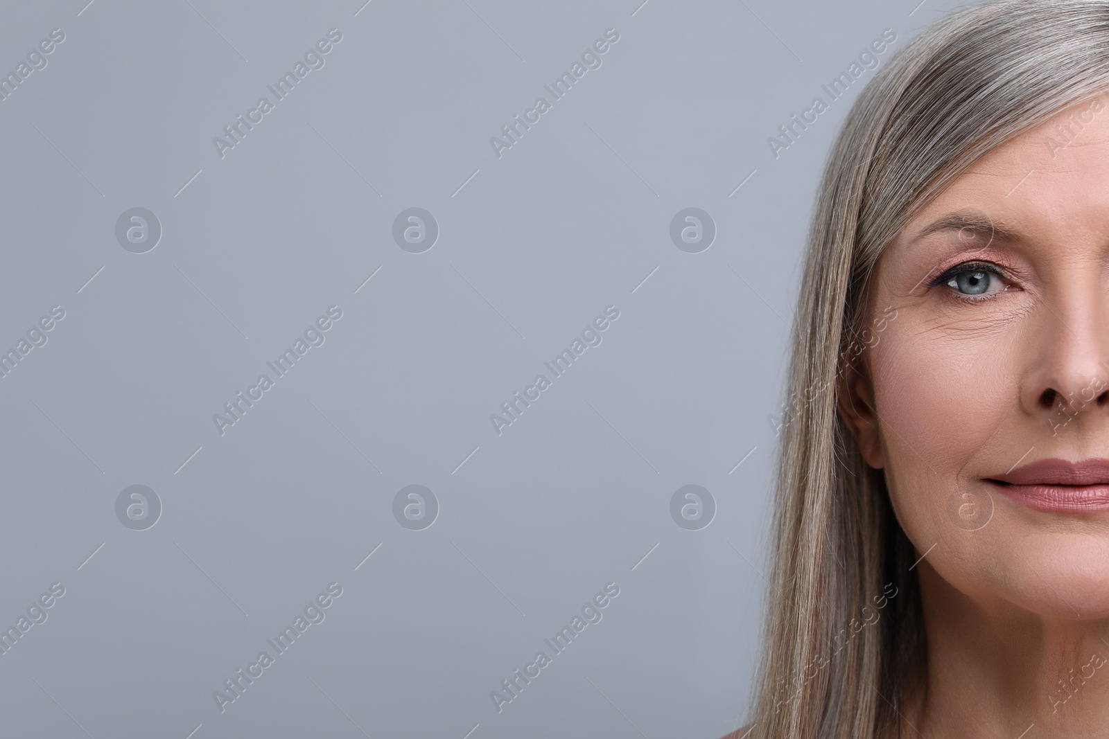 Photo of Portrait of beautiful senior woman on grey background, closeup. Space for text